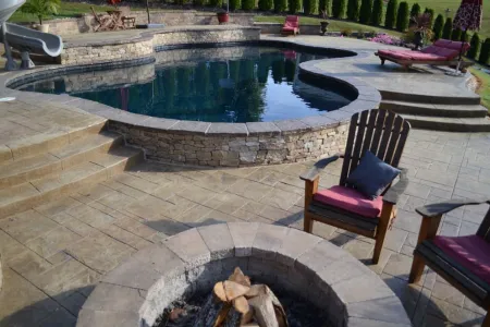 Pool and raised stone-faced spa beside the Pavilion and Fire Pit seating area
