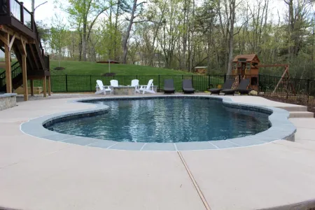 River Bend freeform pool with patio and stone-faced raised edge