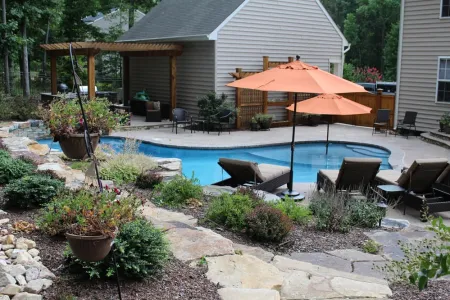 Natural Stone pool beside planting beds, outdoor seating and the home