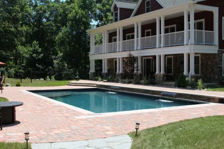 Pine Knoll rectangular pool and paved patio beside the Stafford home