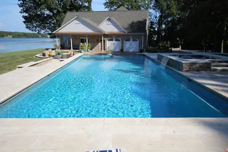 Rectangular McMackin swimming pool with a raised spillover spa beside the Stafford home