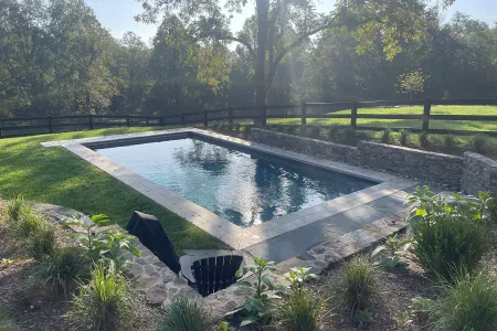 Rizzo-Madison rectangular pool beside lawn, planting and stone-faced wall