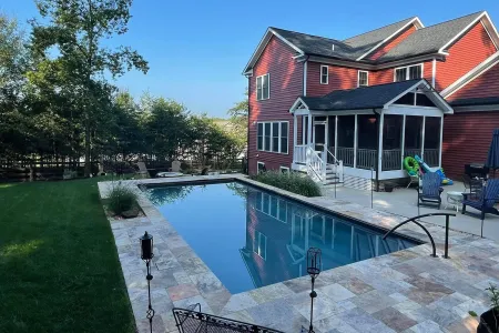 Johnson-Stafford straight-sided pool beside the home and surrounding stone patio