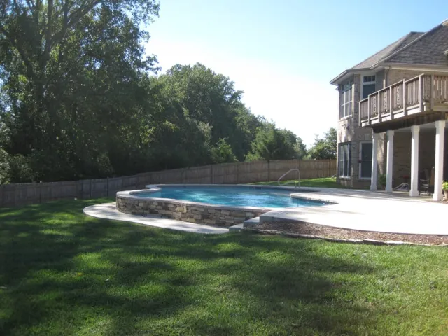 Raised and Reverse Bond Beams pool beside the home and sloping lawn