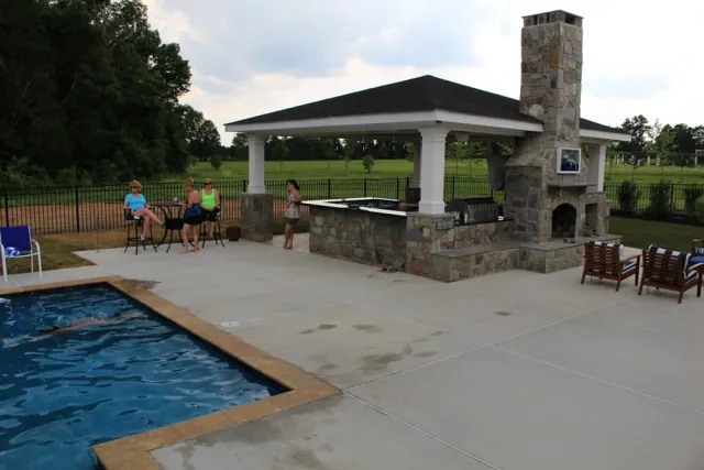 Outdoor pavilion and stone-faced fireplace beside the Backyard Resort pool