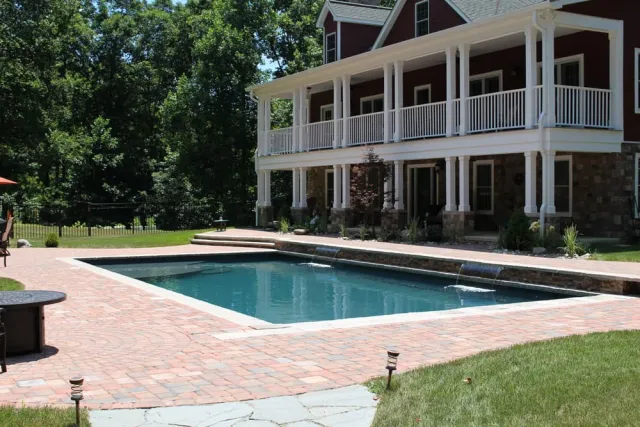 Pine Knoll rectangular pool and paved patio beside the Stafford home