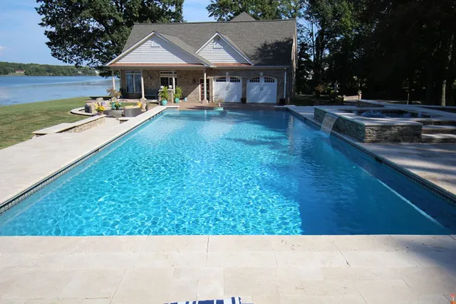 Rectangular McMackin swimming pool with a raised spillover spa beside the Stafford home