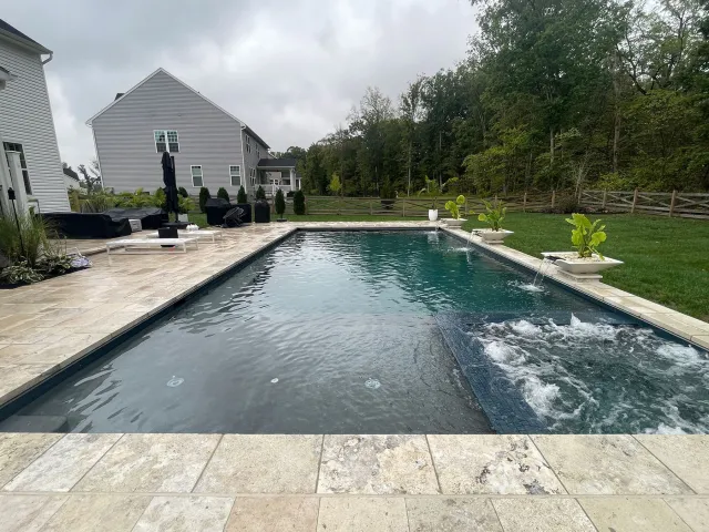 Rectangular Miller-Haymarket pool with patio and water features