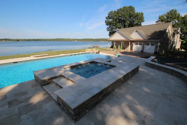 Raised stone-faced spa beside the McMackin pool with the river in the background